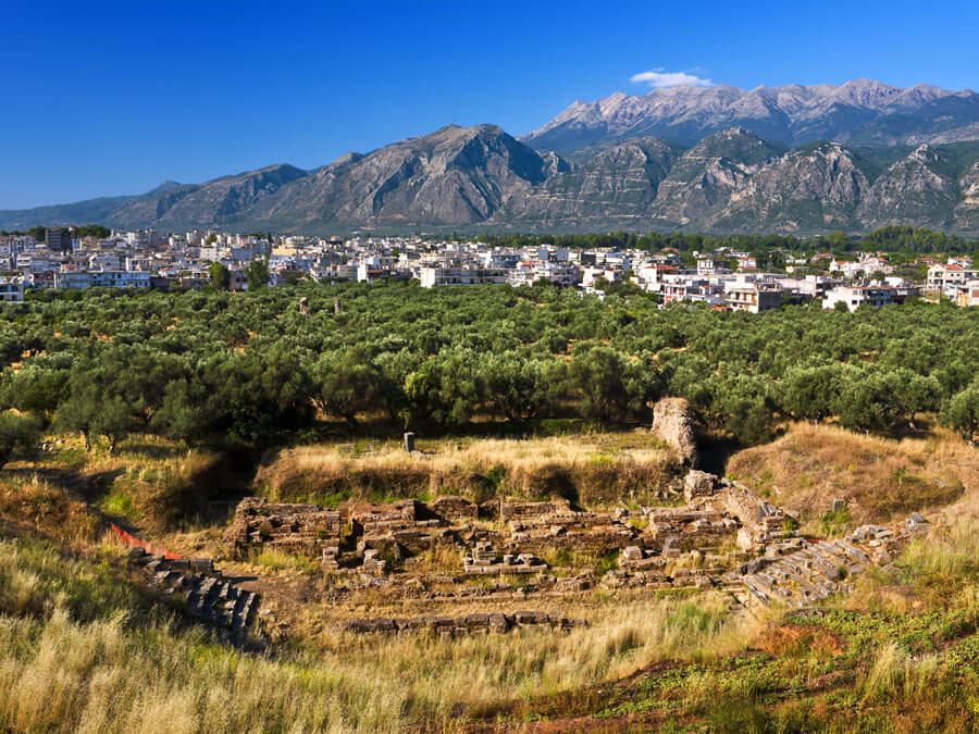 Überreste des antiken Sparta, Ruinen des Theaters. Die moderne Stadt und ein Fragment des Taygetus-Gebirges im Hintergrund