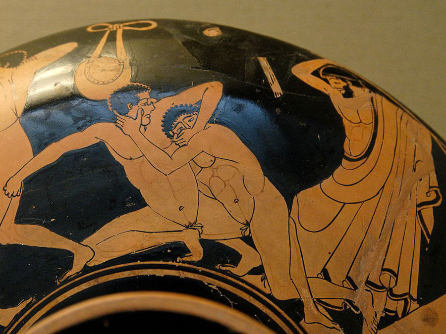 Pankration scene: the pankriatiast on the right tries to gouge his opponent's eye; the umpire is about to strike him for this foul. Detail from an Attic red-figure kylix c. 490-480 BC